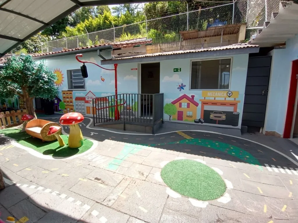 Espaço lúdico ao ar livre do Colégio Siglan em Perus, com circuito pintado e brinquedos